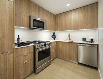 Galley kitchen with stainless appliances and wood finish